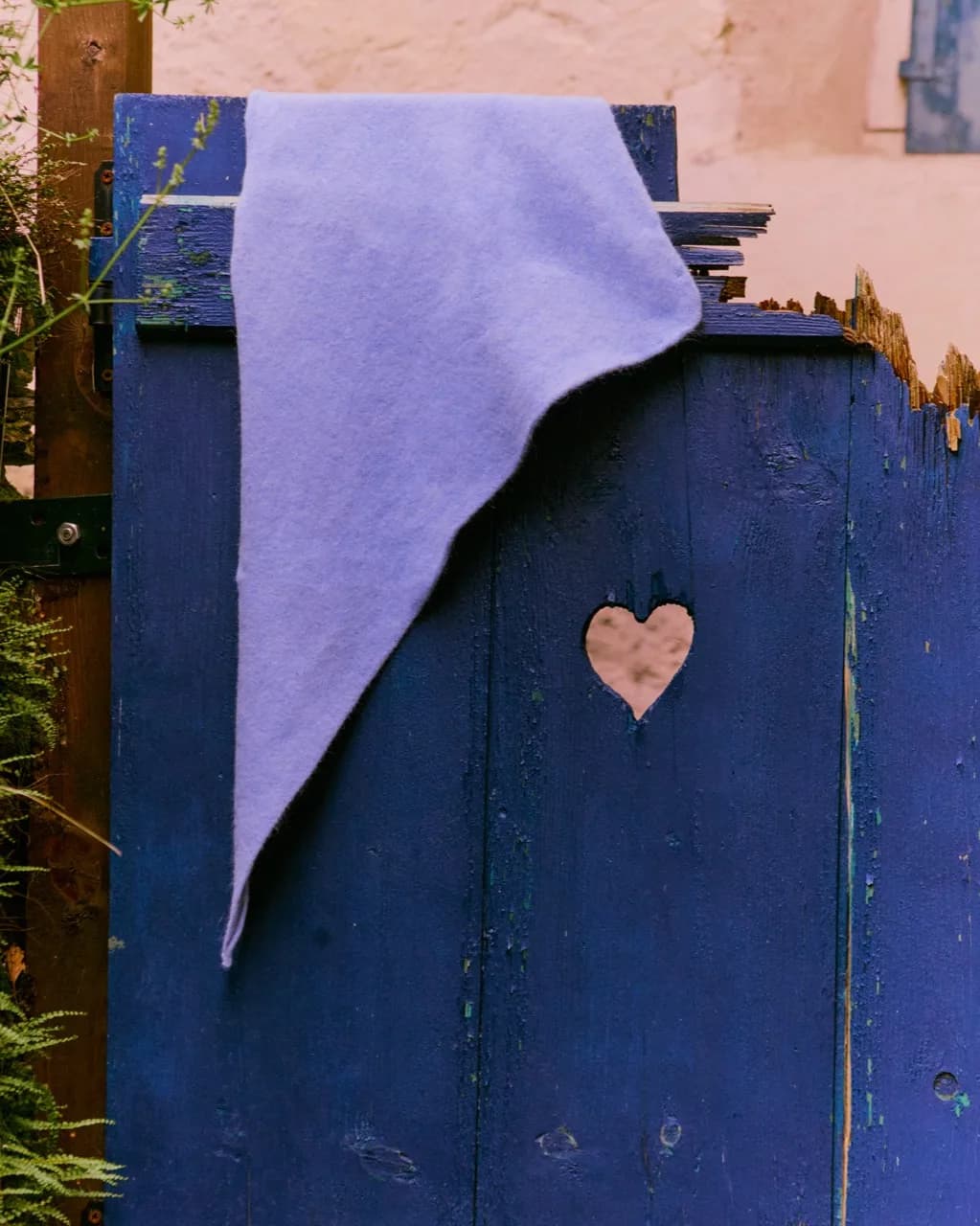 Lila bandana over een blauwe houten poort